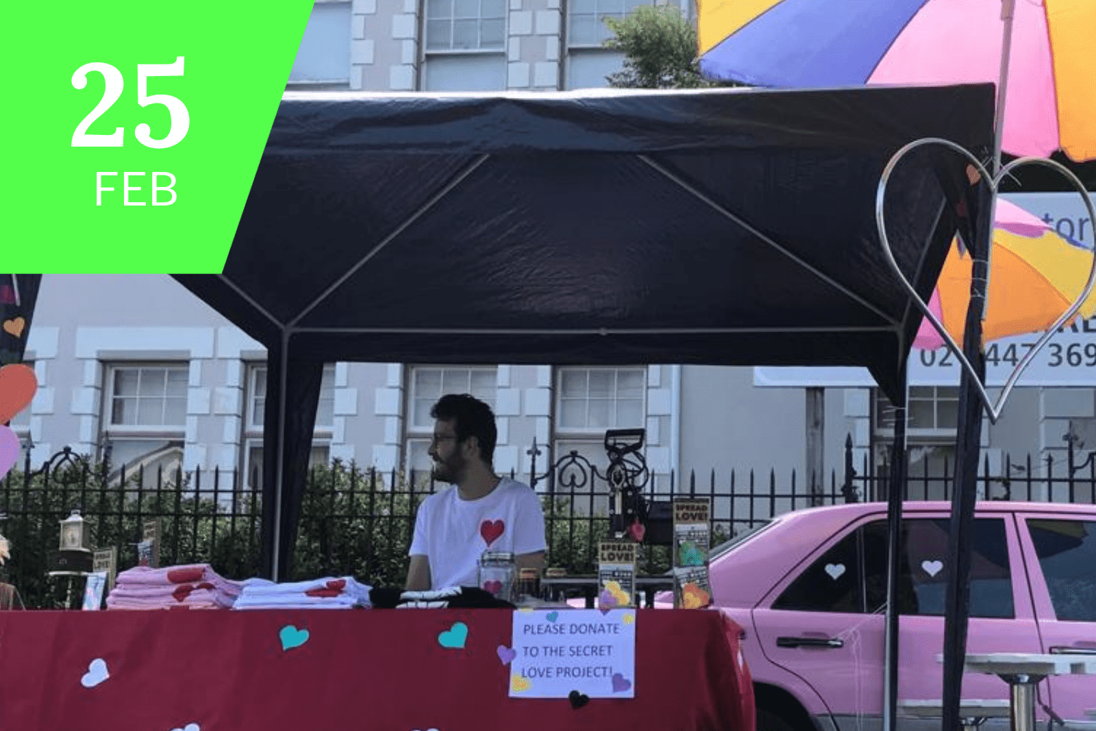 A volunteer selling merchandise for the Secret Love Project at the Open Streets Festival in Observatory